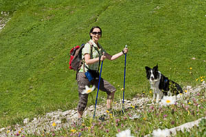 Frau mit Hund beim Bergwandern in der Schweiz